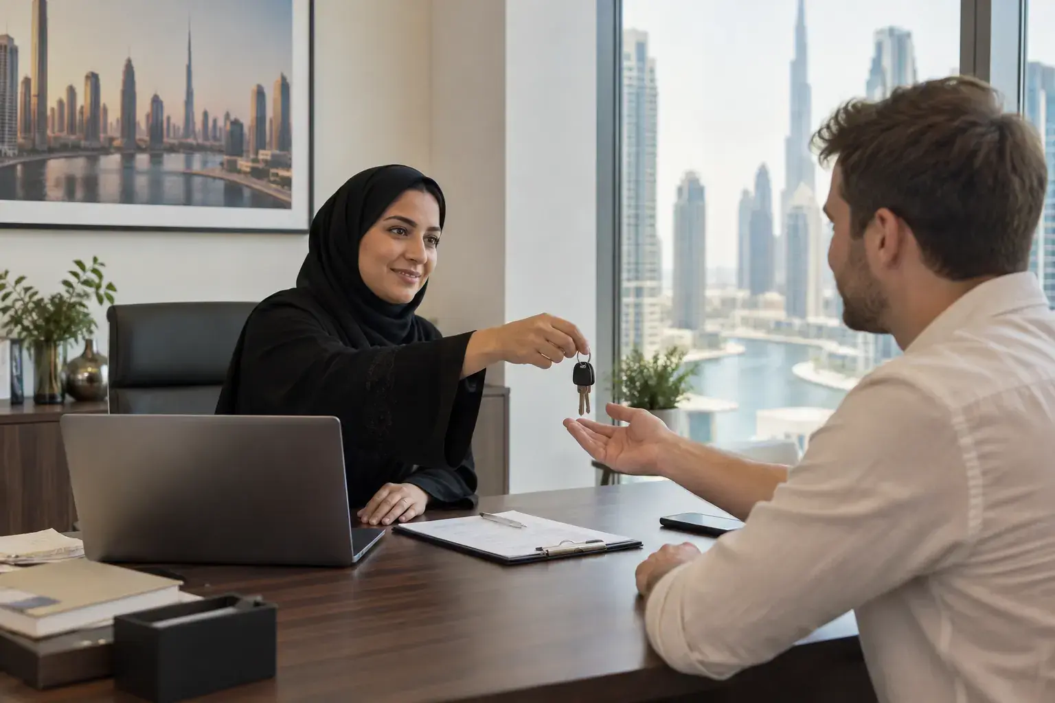 A leasing manager in a Business Bay office hands apartment keys across her desk to a new tenant, with the Dubai skyline behind.